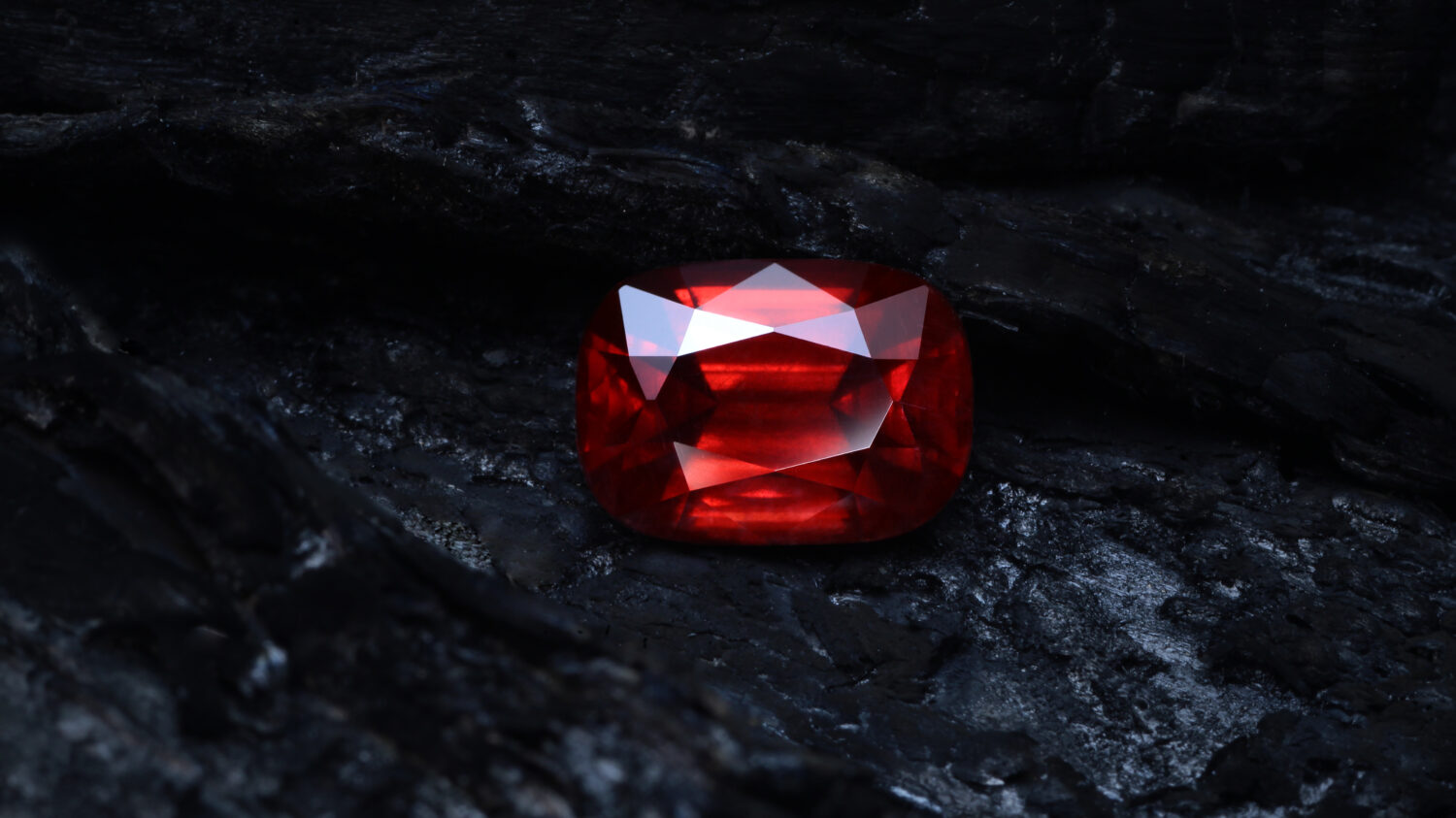 Red garnet rhodolite on coal background.