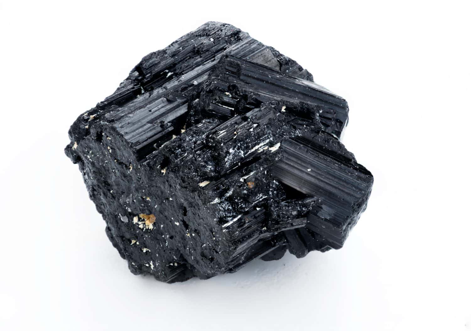 extreme close up of black tourmaline mineral isolated over white background