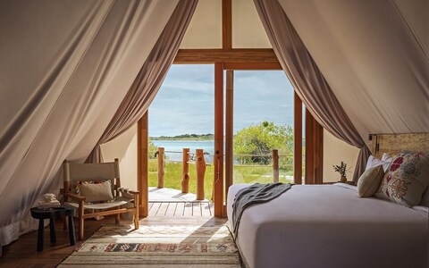 A-tented rooms at Our Habitas Bacalar are heavy on creature comforts with artisanal rugs, blankets and cushions